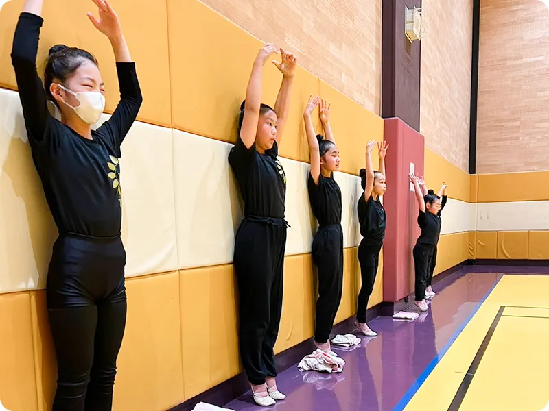 壁際に立つ子供たちの写真